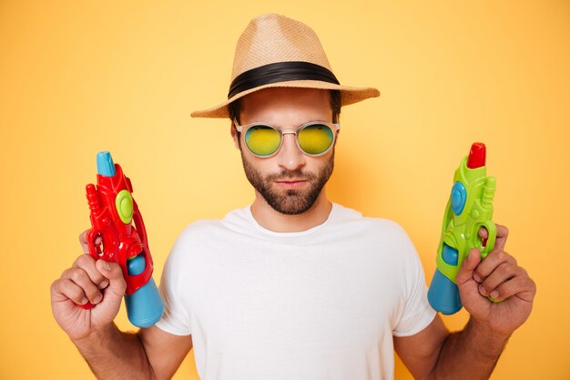 serious-young-man-holding-toy-water-guns_171337-16833.jpg