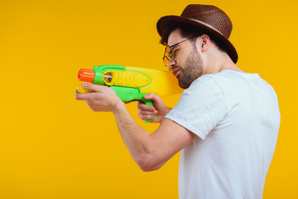 stock-photo-side-view-bearded-young-man-hat-sunglasses-shooting-water-gun.jpeg